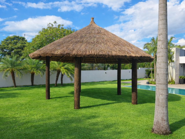 Quiosque de madeira coberto com sapê para piscina